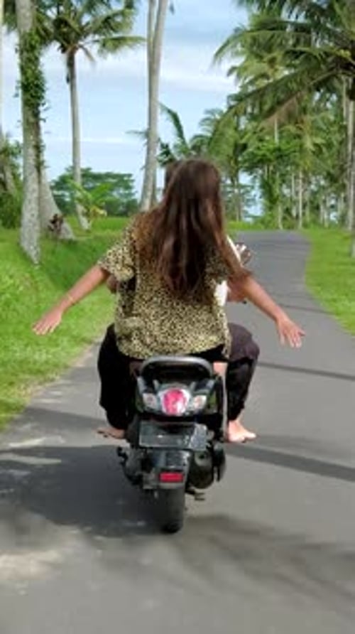 Happy Couple Tourists Riding Scooter in Bali During Summer Vacation