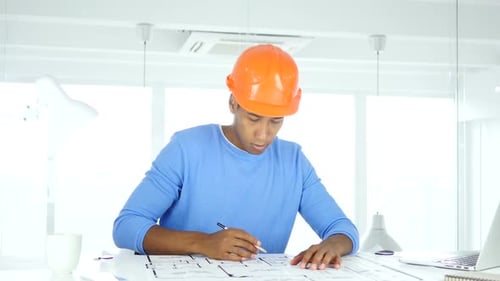 Architectural Engineer Working on Blueprint in His Office