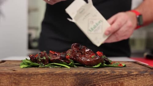 Chef Seasoning Cooked Steak on Wooden Cutting Board