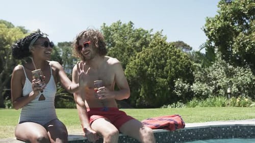 Friends Relaxing By Tropical Pool in Summertime