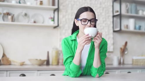 Woman Enjoying Coffee in Bright Modern Kitchen