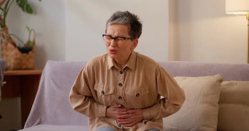 Woman Experiencing Abdominal Pain Indoors