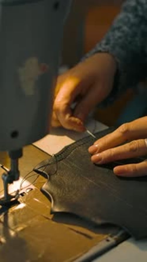 Person Sewing Dark Fabric on Sewing Machine