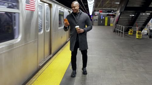 Businessman Using Smartphone While Train Arriving at Subway Station