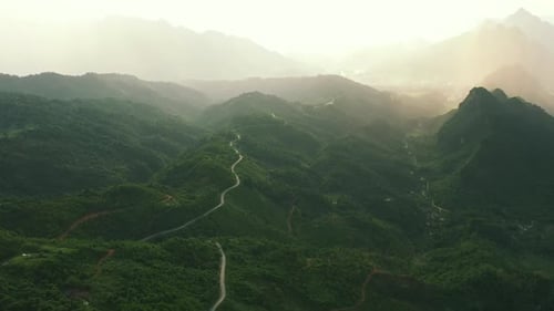Mountains, green forest and drone with hills, path and landscape scenery with sunset