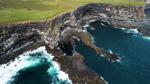 Aerial view of ocean waves crashing along the coast in Hvalnes Nature Reserve, Eastern, Iceland.