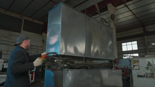 View inside of factory workshop with crane transporting metal detail