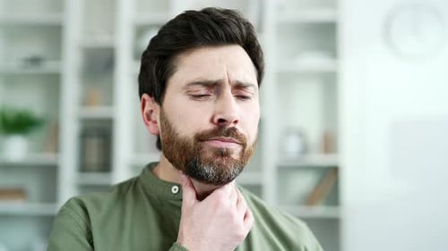 Man Holding Sore Throat in Pain