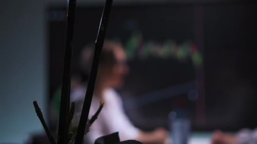 Woman and Man at Table in Hightech Office Analyzing Stock Market Charts on Screen
