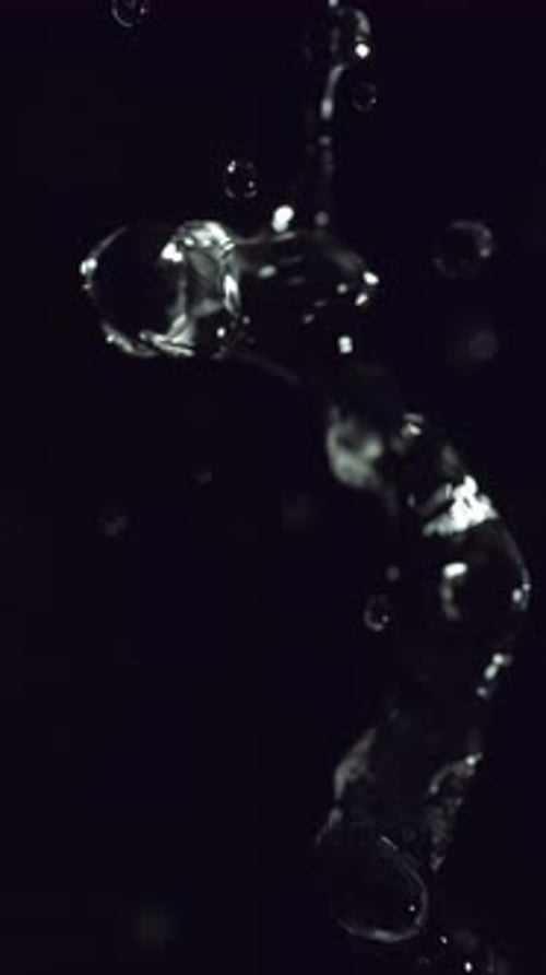 Water Flowing Dynamically Against a Black Backdrop