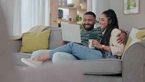 Couple Relaxing on Couch with Laptop Indoors
