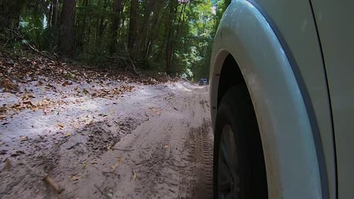 Vista en punto de vista más allá de la rueda delantera de un camión todoterreno 4WD blanco desde una cámara montada en un automóvil, mientras rebota