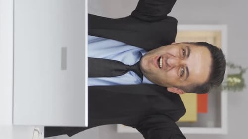 Vertical video of Home office worker man experiencing joy looking at camera.