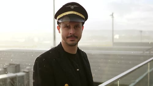 Handsome Pilot in Uniform at Airport Terminal