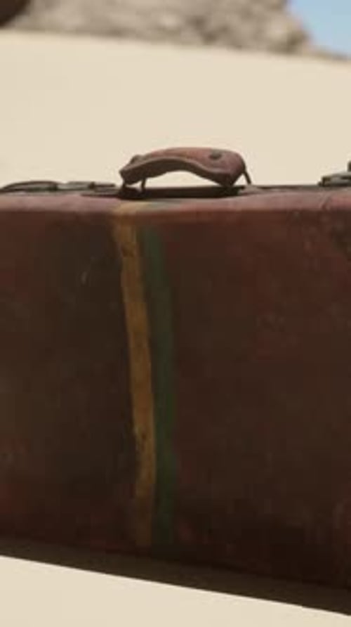 A Piece of Luggage Sitting on Top of a Sandy Beach