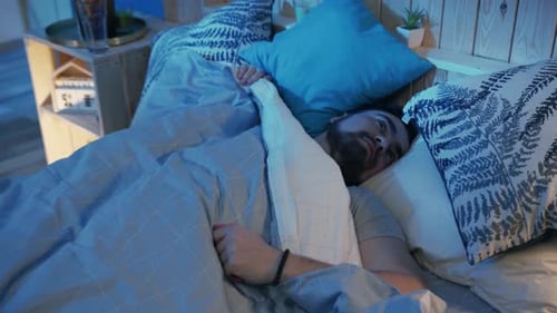 Man Sleeping Soundly in Bed at Night
