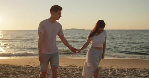 Young Loving Couple Enjoying Relaxing Sunset Walk on the Beach