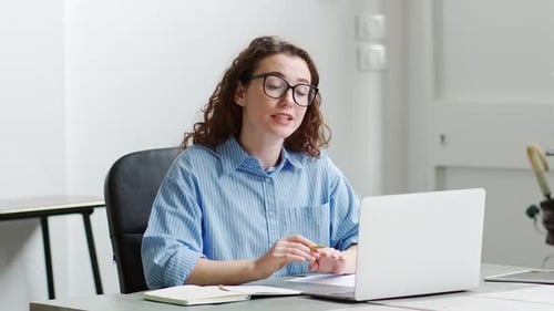 Woman Video Conferencing at Desk in Modern Office