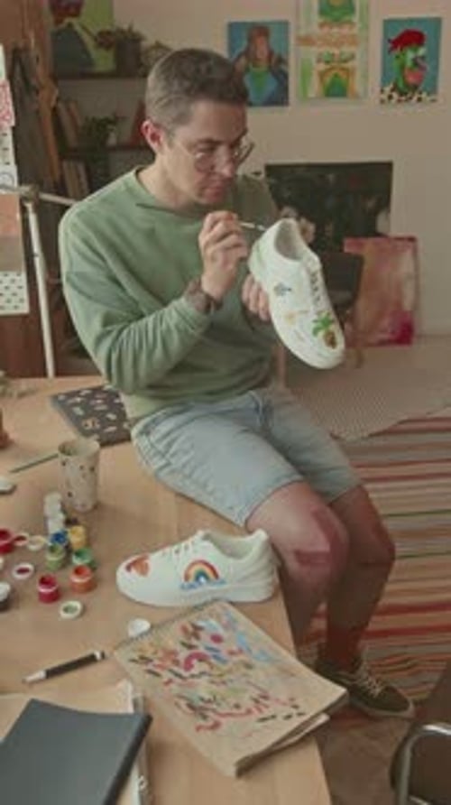 Male Creative Artist Drawing Pictures on Sneakers in Studio