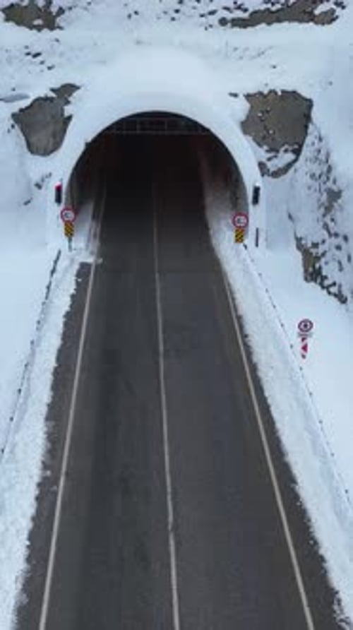 Cars Entering Snowy Tunnel in Winter Aerial View