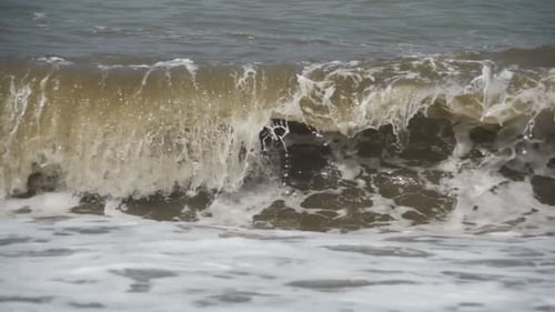 Sturm auf dem Meer Die Wellen rollen an einem Kieselsteinstrand Zeitlupe