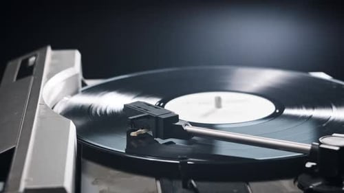 Hand Places Needle on Spinning Vinyl Record