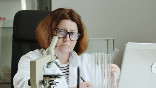 Female Scientist Examining Test Tubes in Laboratory