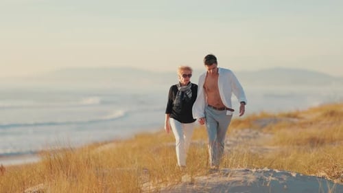 Romantic Couple Holding Hands Walking on a Sandy Dune at