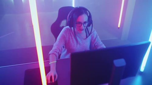 Woman Playing Video Games in Colorful Lit Room