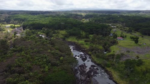4K cinematic clockwise drone shot of a river flowing through a tropical jungle near Hilo on the Big