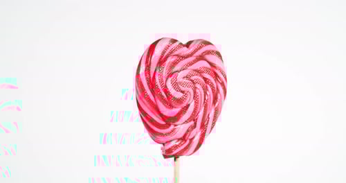 Swirling Red Heart Lollipop Against White Background