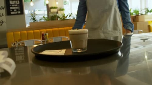 Kellnerin steht am Tresen in der Cafeteria 4k