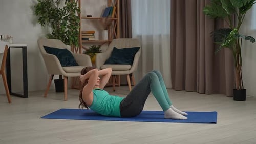 Woman Doing Sit Ups on Exercise Mat at Home