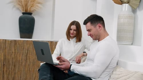 Couple Using Laptop Together on Couch at Home