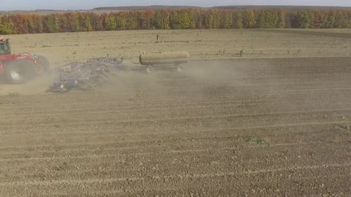 Big red combine working on the field cultivating and applying nitrogen ASP