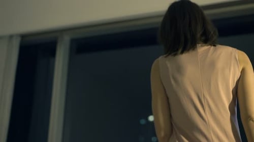 Woman Relaxing in Chair Overlooking Night Cityscape