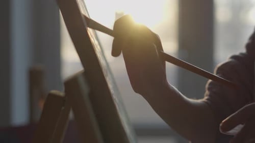 Artist Painting on Canvas with Golden Sunlight