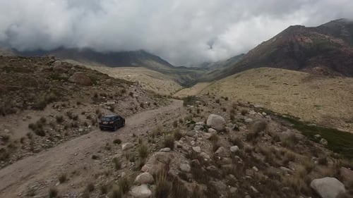 Drone: flies behind a car through a gorge in the mountains of Kyrgyzstan