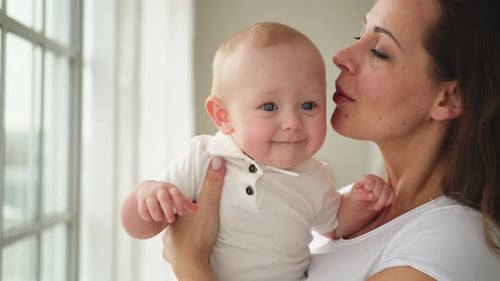 Mother Holds Baby in Bright Indoor Scene
