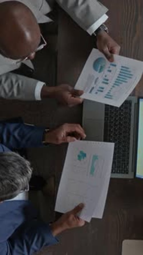 Vertical of Two Diverse Businessmen Working on Presentation in Office