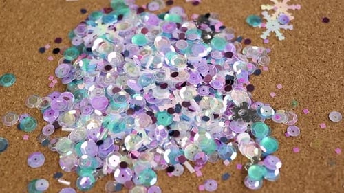 Des paillettes de couleur froide scintillent sur un tapis en liège. Matériel pour l'artisanat.