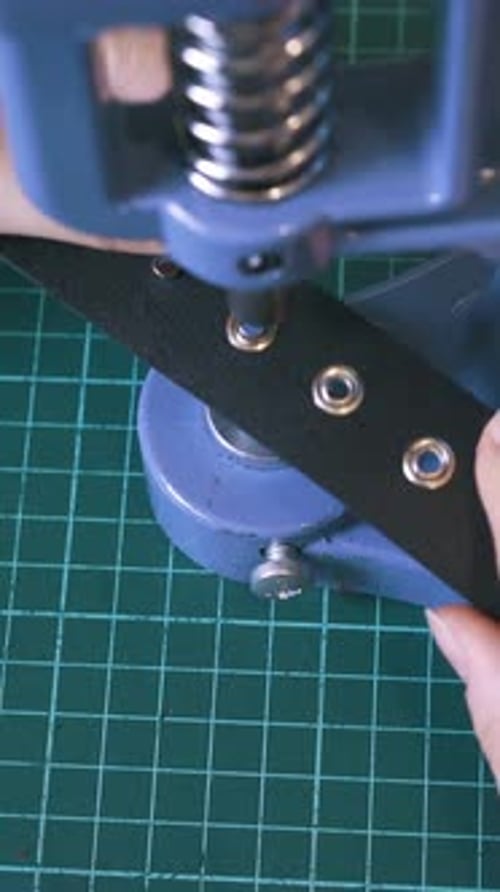 Attaching Metal Eyelets to Black Material with Tool