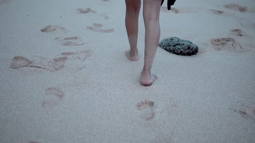 Barefoot woman walking on tropical sandy beach in slow motion