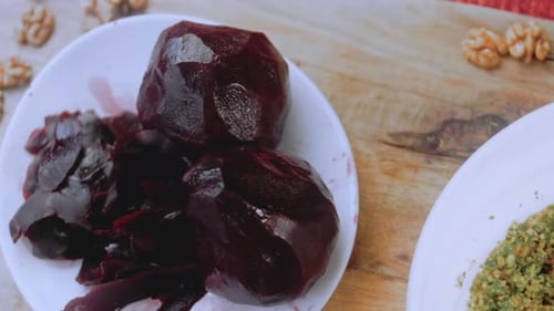 Female Hands Cut the Beetroot on a Kitchen Board with a Knife