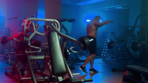 Man Lifting Weights at Modern Gym at Night