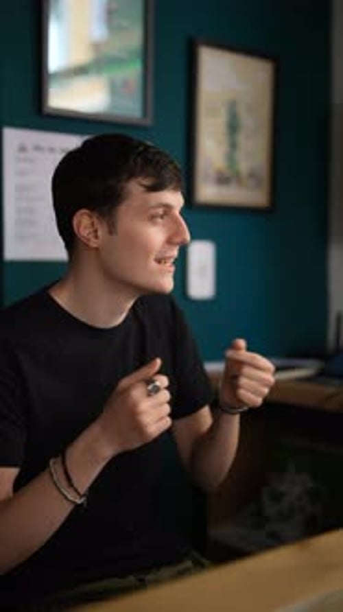 A Young Man Engaged in a Candid Discussion in the Workplace Captured in Animated Shots