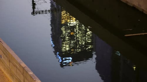 Skyscraper reflection in water, lights in the offices at night