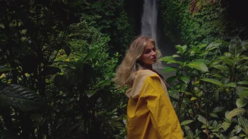 Blonde Girl Exploring Waterfall in Bali Indonesia Woman in Yellow Raincoat Enjoying Vacation Trip