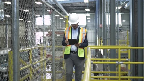 Transit Supervisor Walking with Digital Tablet in Maintenance Facility Adult