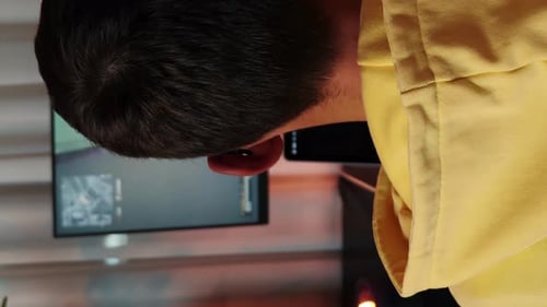 Young Man Plays Video Game Wearing Headphones